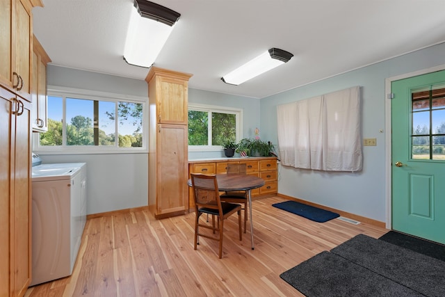 dining room featuring washing machine and clothes dryer and light hardwood / wood-style floors