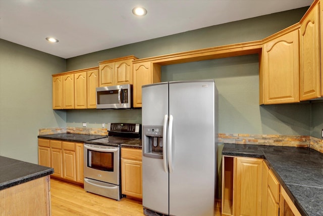 kitchen featuring light brown cabinetry, light hardwood / wood-style flooring, and appliances with stainless steel finishes