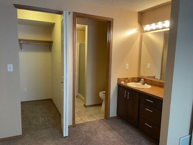 5307 N Argonne Ln # 6, Spokane, WA 99212 - full bath with toilet, vanity, a stall shower, and a textured ceiling