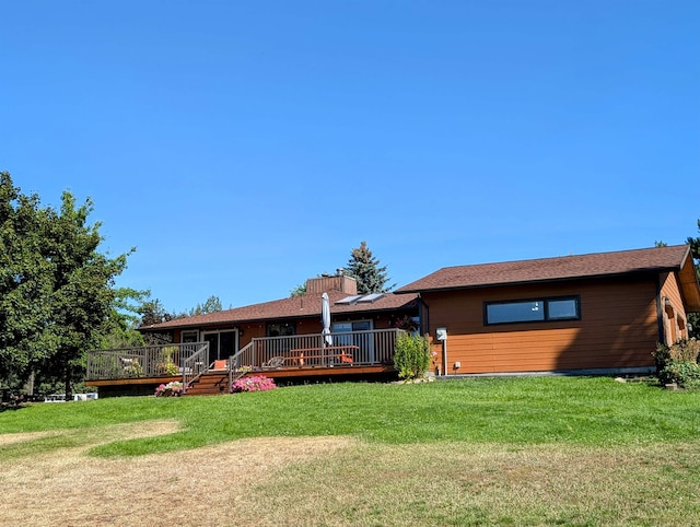 back of house with a wooden deck and a yard