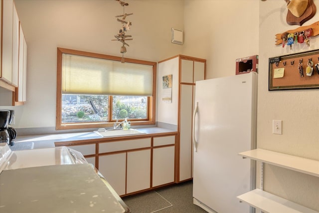 16547 E Whitelaw Rd, Wilbur, WA 99185 - kitchen featuring a sink, light countertops, freestanding refrigerator, and white cabinets
