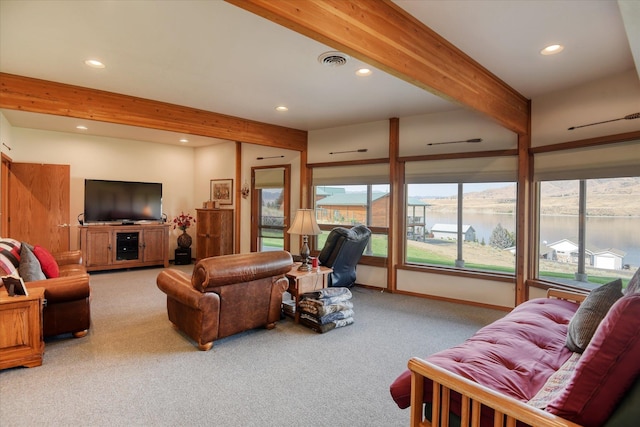 living room featuring a water view, beam ceiling, and carpet flooring