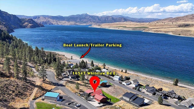 birds eye view of property featuring a water and mountain view and a beach view