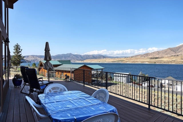 wooden deck with a water and mountain view