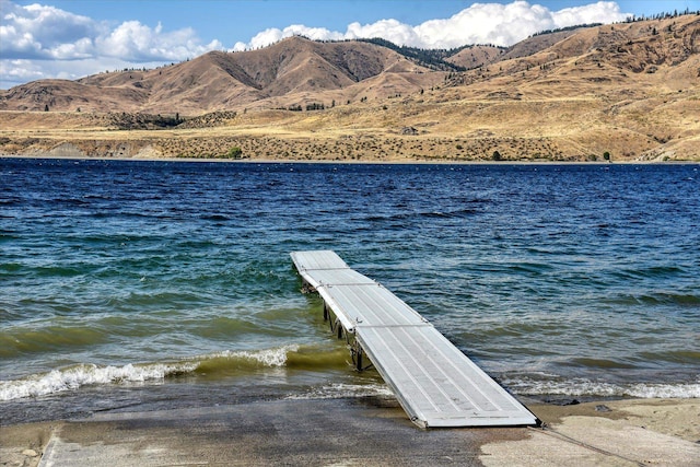 view of dock with a water and mountain view