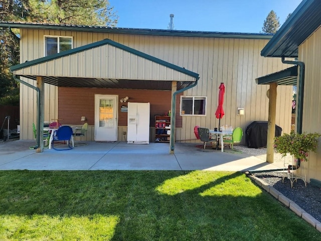 back of property featuring a lawn and a patio area