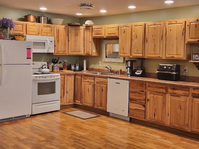 kitchen with white appliances, recessed lighting, a sink, and light wood-style floors