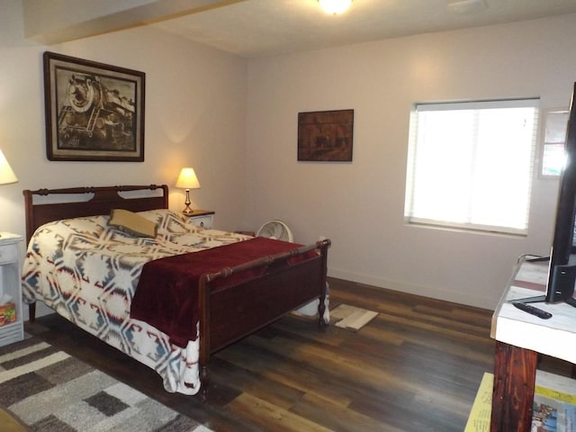 bedroom with baseboards and wood finished floors