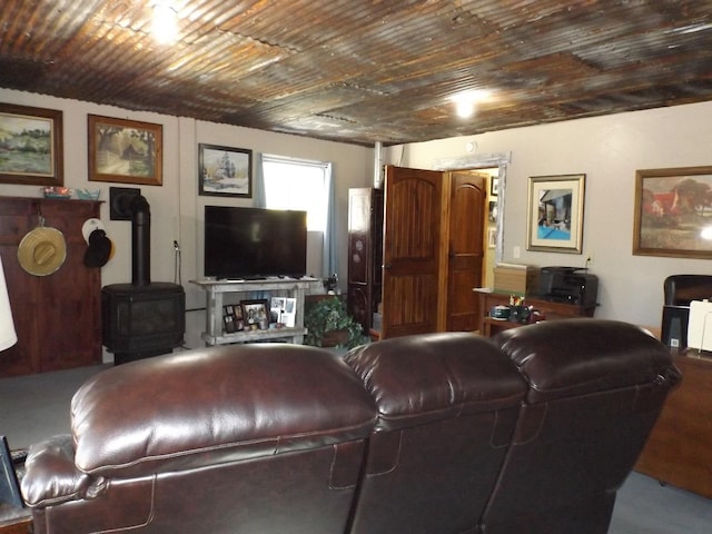living room featuring a wood stove and wooden ceiling
