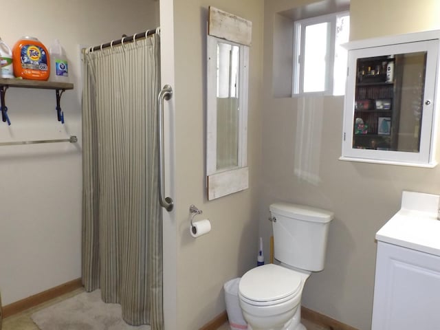 bathroom with toilet, baseboards, curtained shower, and vanity