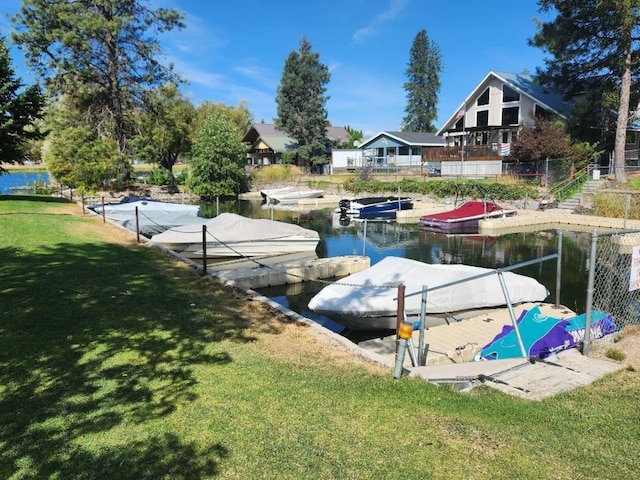 view of dock featuring a lawn and a water view