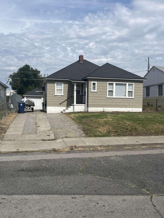 view of front facade featuring a garage and an outdoor structure