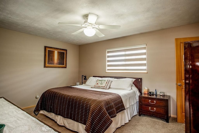 bedroom featuring a textured ceiling, baseboards, a ceiling fan, and light colored carpet