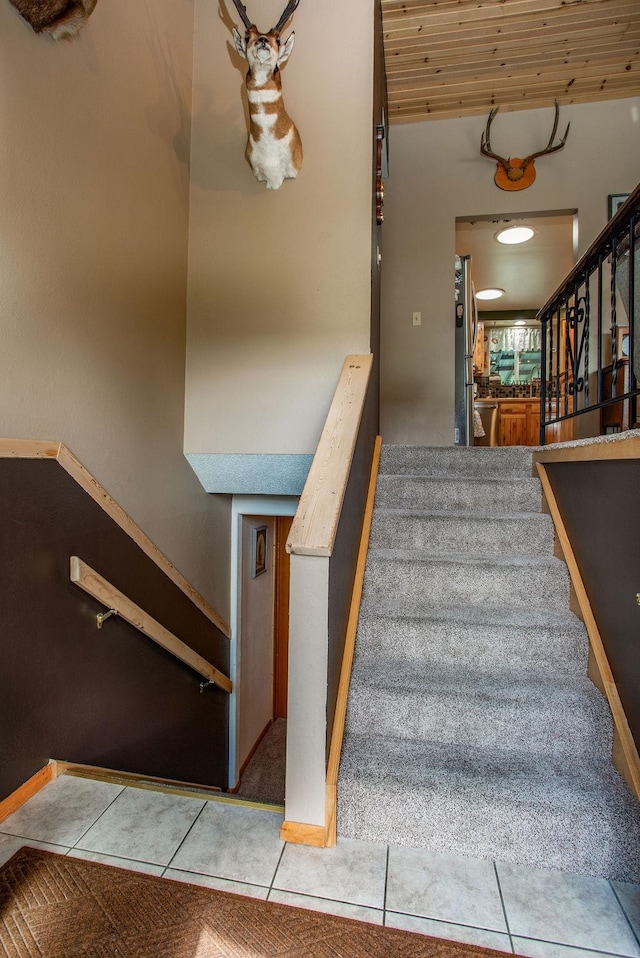 stairway with tile patterned flooring and wooden ceiling