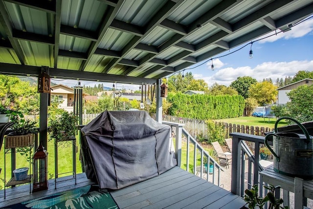 wooden deck featuring a lawn, grilling area, and a fenced backyard