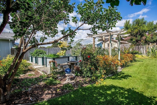 view of yard featuring a pergola, a vegetable garden, and fence