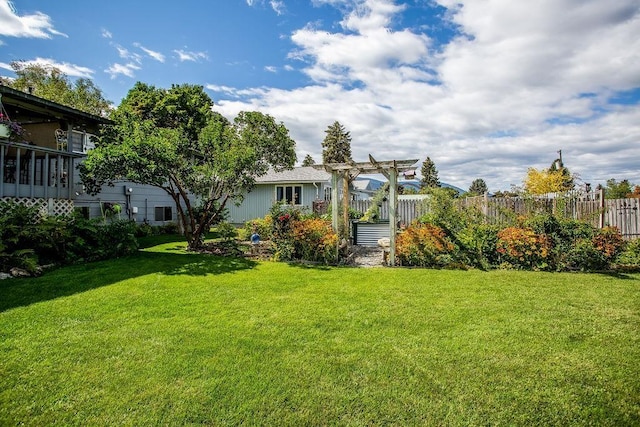 view of yard with fence and a pergola