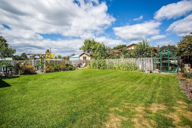 view of yard with a fenced backyard, an outbuilding, a pergola, and an exterior structure