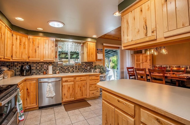 kitchen with light tile patterned floors, appliances with stainless steel finishes, tasteful backsplash, sink, and a chandelier