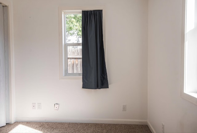 carpeted spare room featuring baseboards
