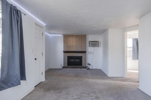 unfurnished living room featuring carpet, a brick fireplace, baseboards, and a wall mounted AC