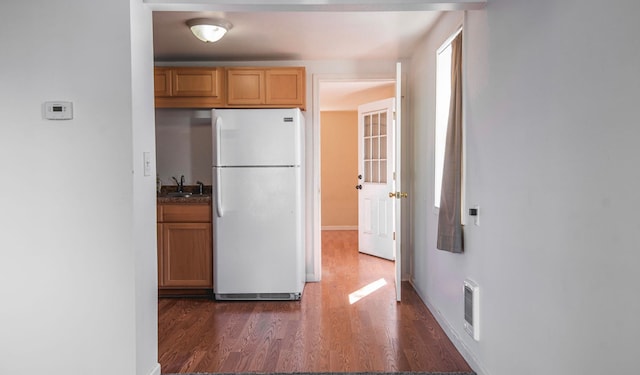 kitchen featuring white refrigerator, dark hardwood / wood-style flooring, and sink