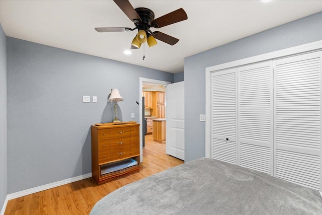 bedroom with light hardwood / wood-style flooring, ceiling fan, and a closet