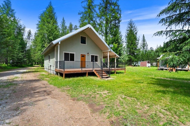 back of house featuring a yard, a storage shed, and a deck