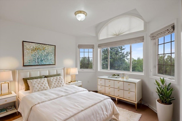 bedroom with multiple windows and lofted ceiling