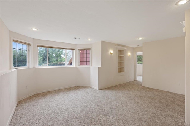 carpeted spare room featuring a healthy amount of sunlight