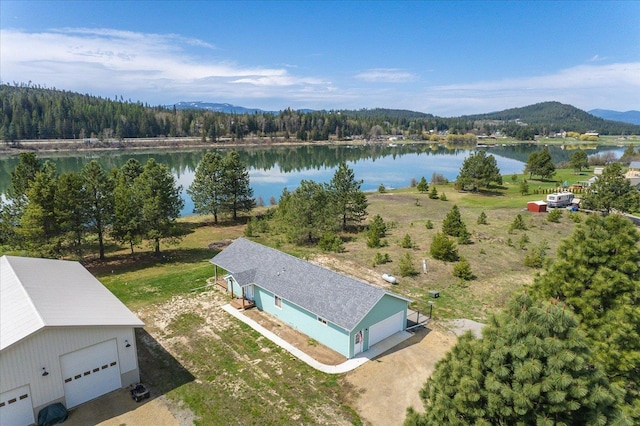 drone / aerial view with a water view and a forest view