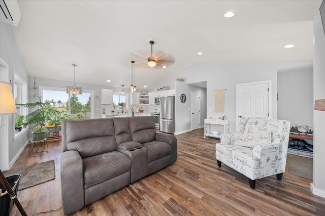 living area with a wall unit AC, recessed lighting, ceiling fan with notable chandelier, vaulted ceiling, and dark wood-style floors