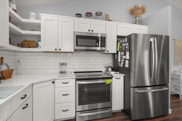 kitchen with open shelves, tasteful backsplash, light countertops, appliances with stainless steel finishes, and vaulted ceiling