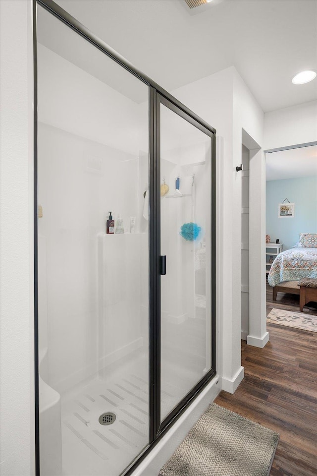 full bathroom with ensuite bathroom, baseboards, wood finished floors, and a shower stall