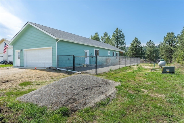 view of property exterior featuring fence, an attached garage, and a lawn