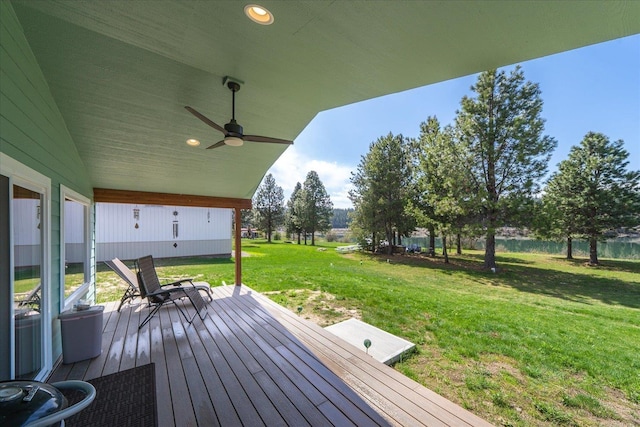 wooden deck featuring ceiling fan and a yard