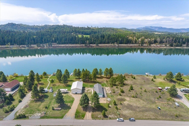 drone / aerial view with a wooded view and a water and mountain view