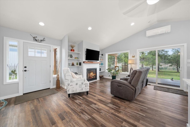 living room featuring lofted ceiling, recessed lighting, wood finished floors, a wall mounted air conditioner, and a glass covered fireplace