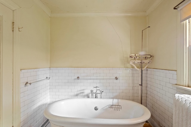 bathroom with crown molding, tile walls, and a tub