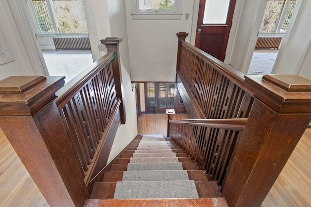 stairs with radiator heating unit and hardwood / wood-style floors