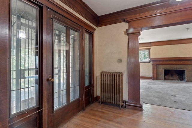 entryway featuring ornamental molding, radiator, and light hardwood / wood-style floors