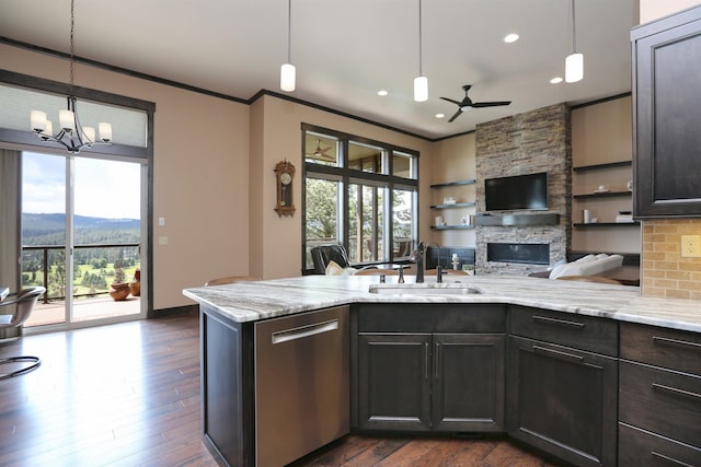 kitchen featuring dishwasher, open floor plan, a sink, and crown molding