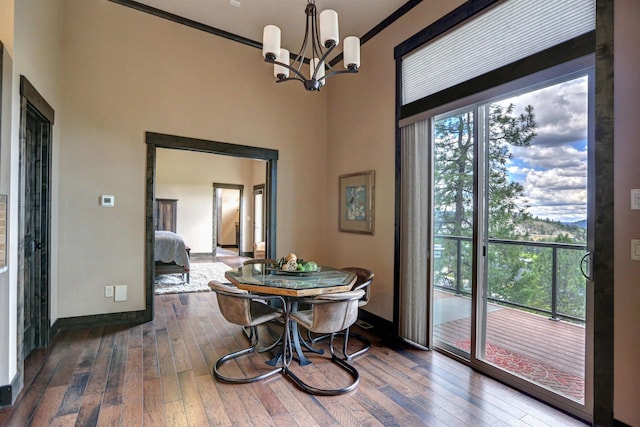 dining area featuring crown molding, wood-type flooring, an inviting chandelier, and a healthy amount of sunlight