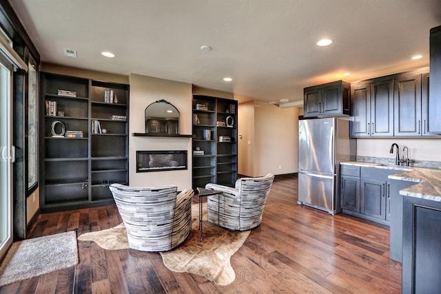 interior space featuring light stone counters, freestanding refrigerator, dark wood finished floors, and recessed lighting