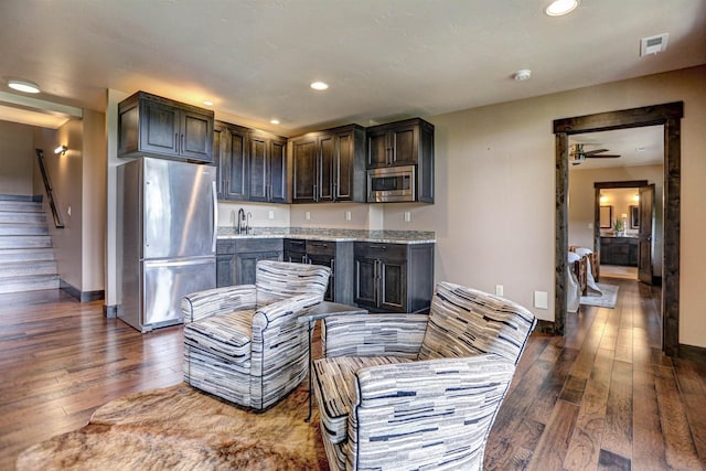 kitchen featuring dark brown cabinetry, visible vents, dark wood-type flooring, stainless steel appliances, and recessed lighting