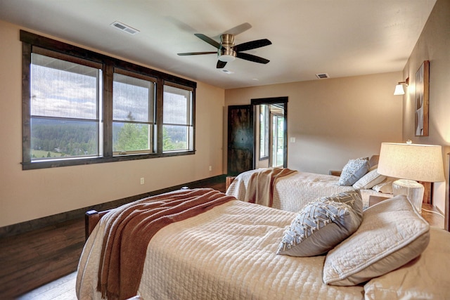 bedroom featuring baseboards, visible vents, and wood finished floors