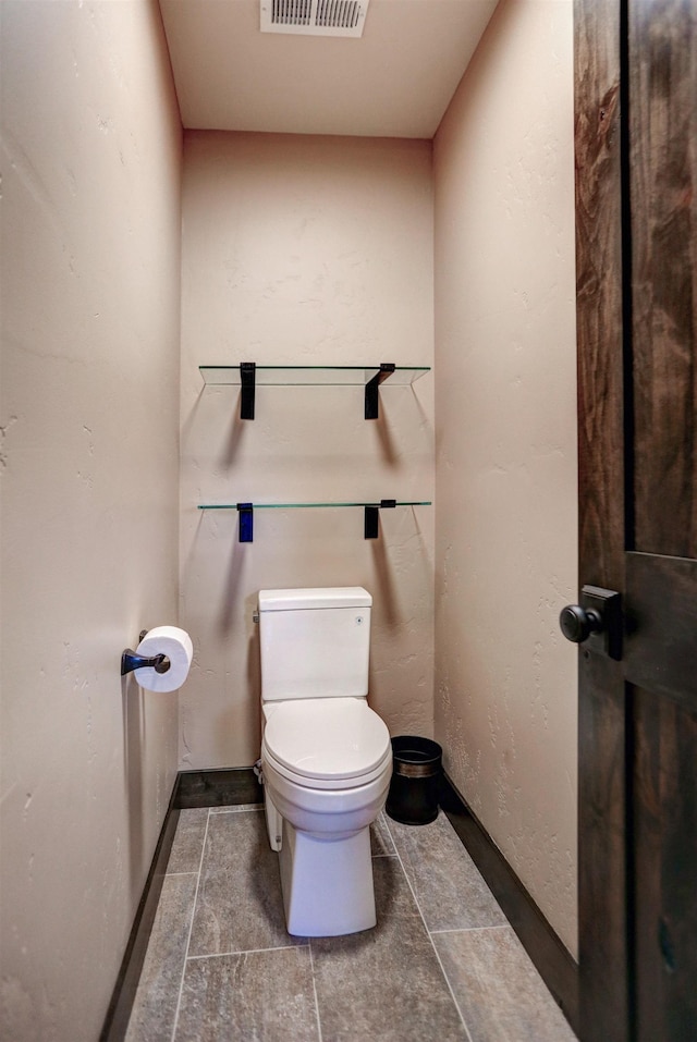 bathroom with toilet, baseboards, and visible vents