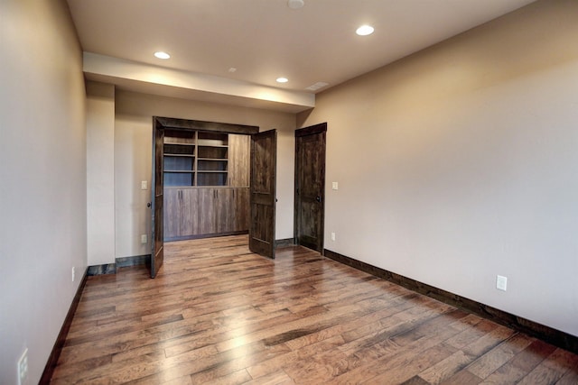 unfurnished bedroom featuring recessed lighting, wood finished floors, and baseboards