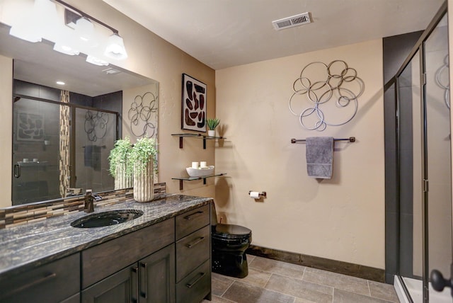 bathroom with a shower stall, visible vents, baseboards, and vanity