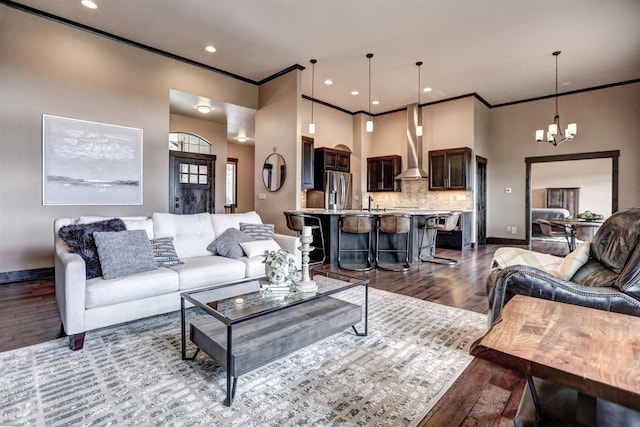 living area with baseboards, ornamental molding, dark wood-style flooring, a notable chandelier, and recessed lighting